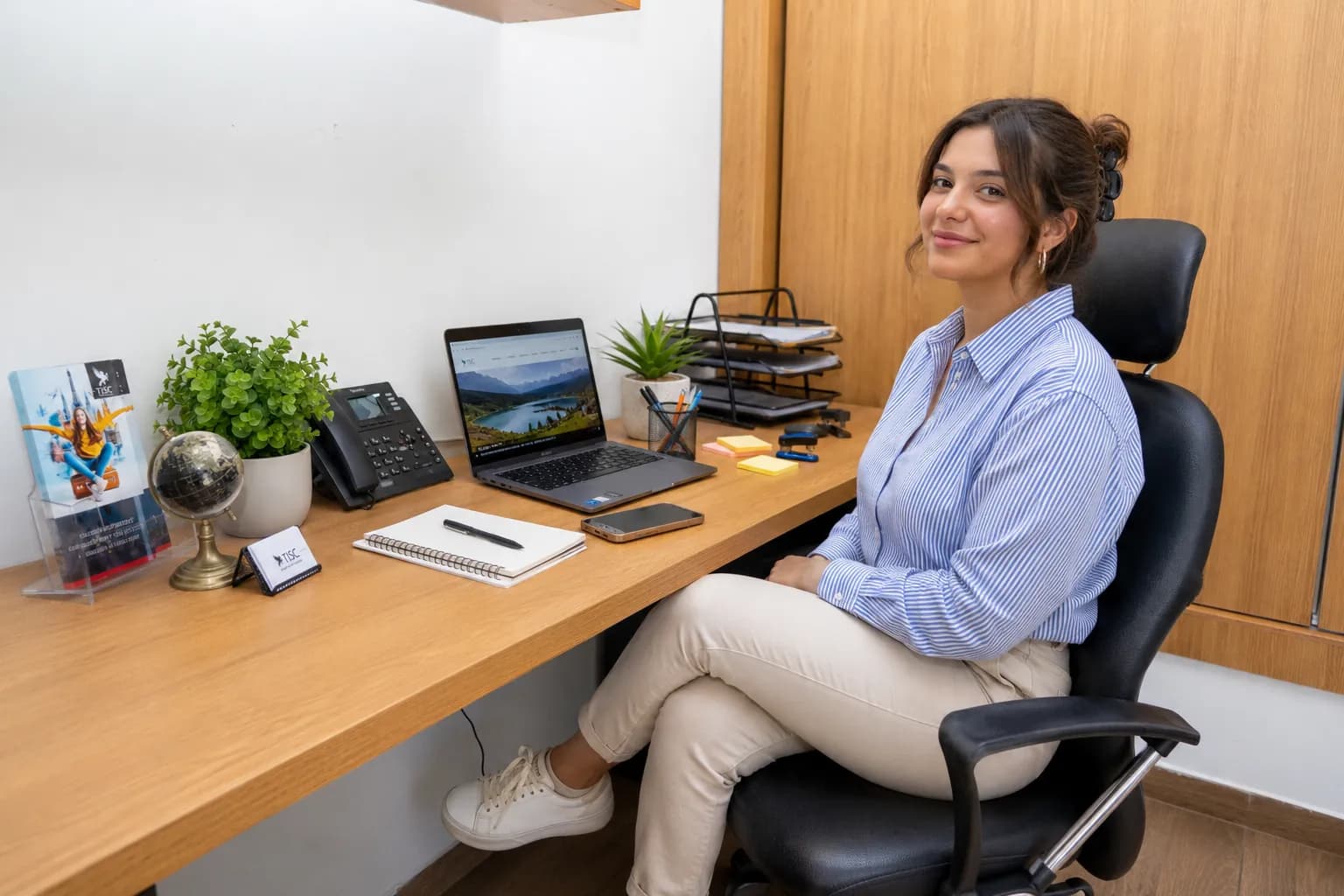 TISC advisor at her desk with a globe and the website open on her laptop