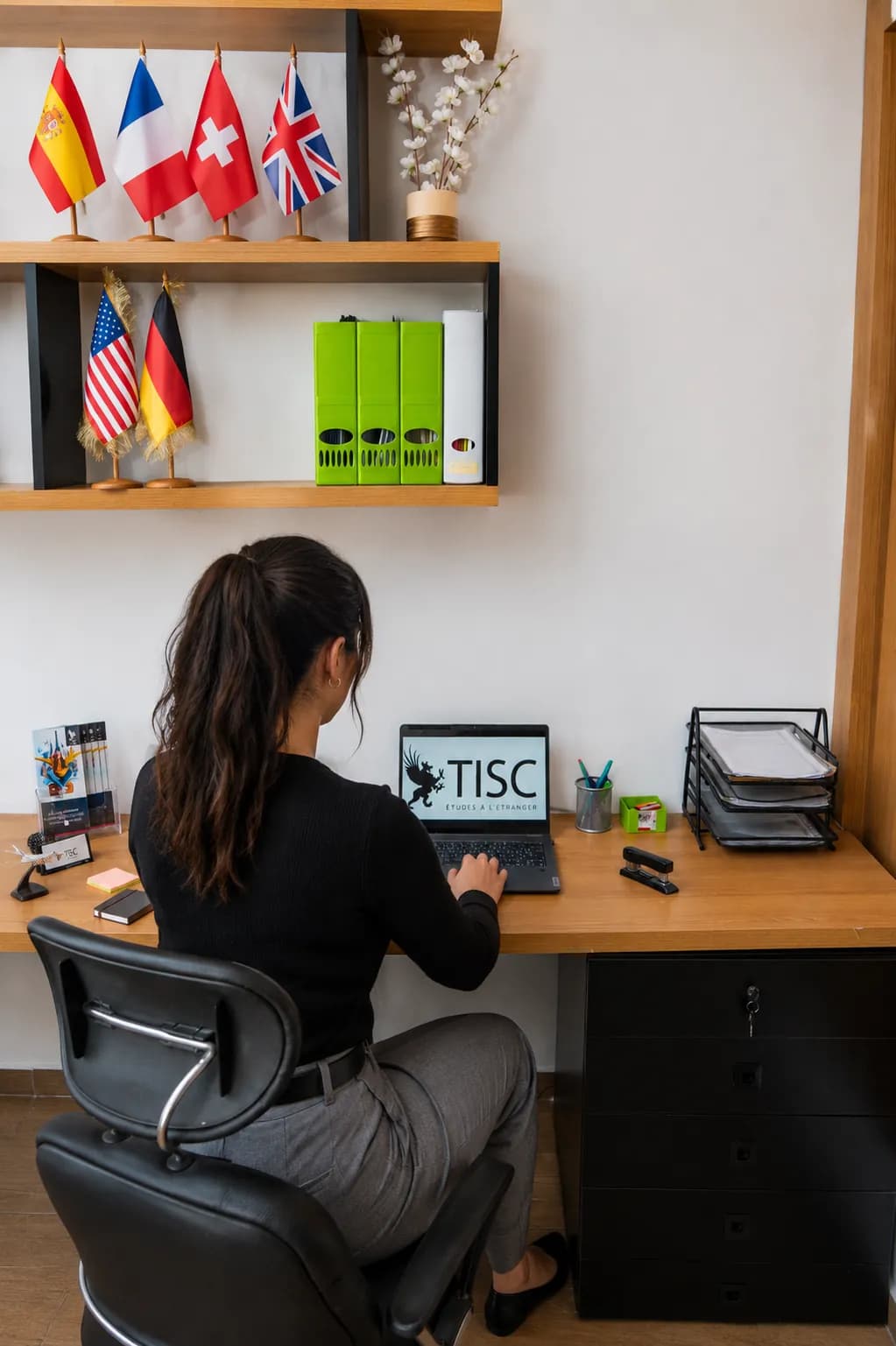 TISC advisor at work beneath a shelf of country flags