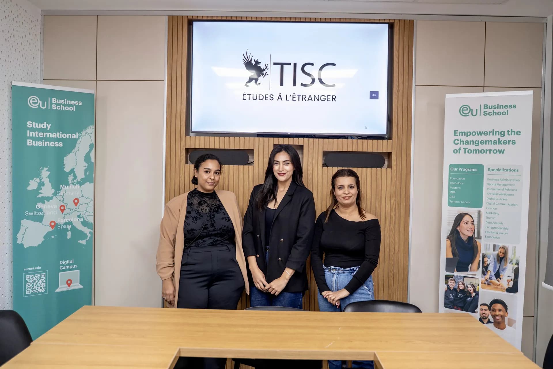 TISC team in front of the TISC screen at an EU Business School event